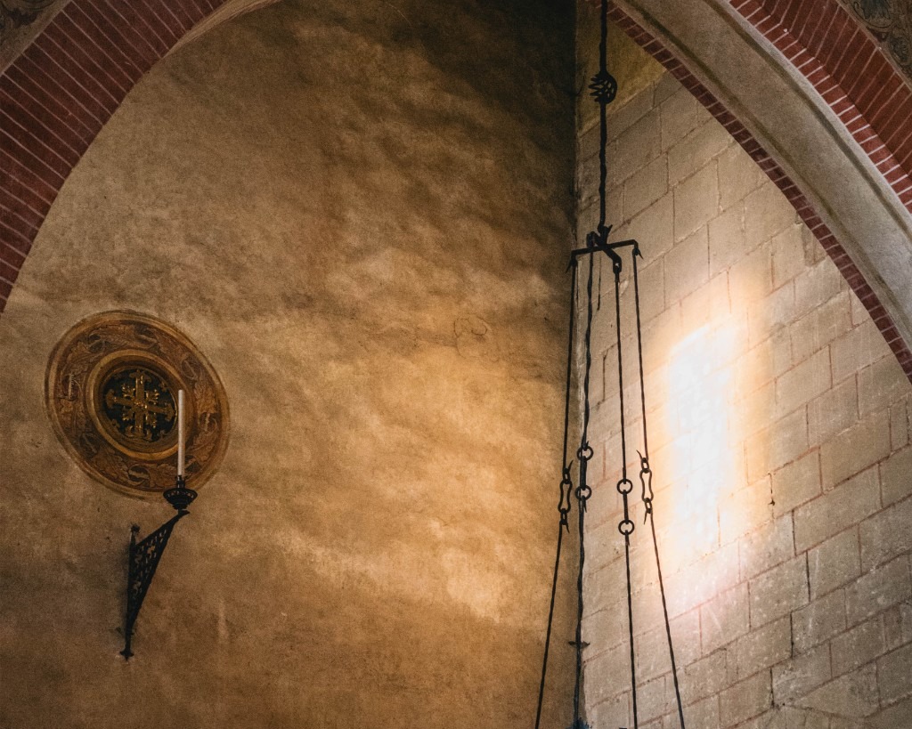 Historic lamp and arches inside Follina Abbey