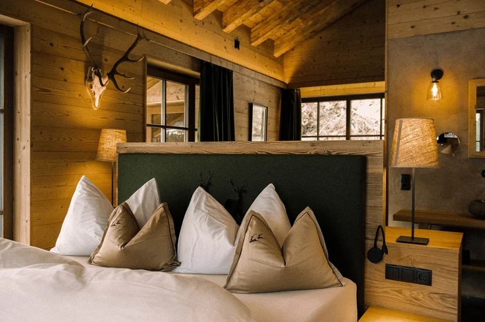 Chalet bedroom · timber walls and green headboard