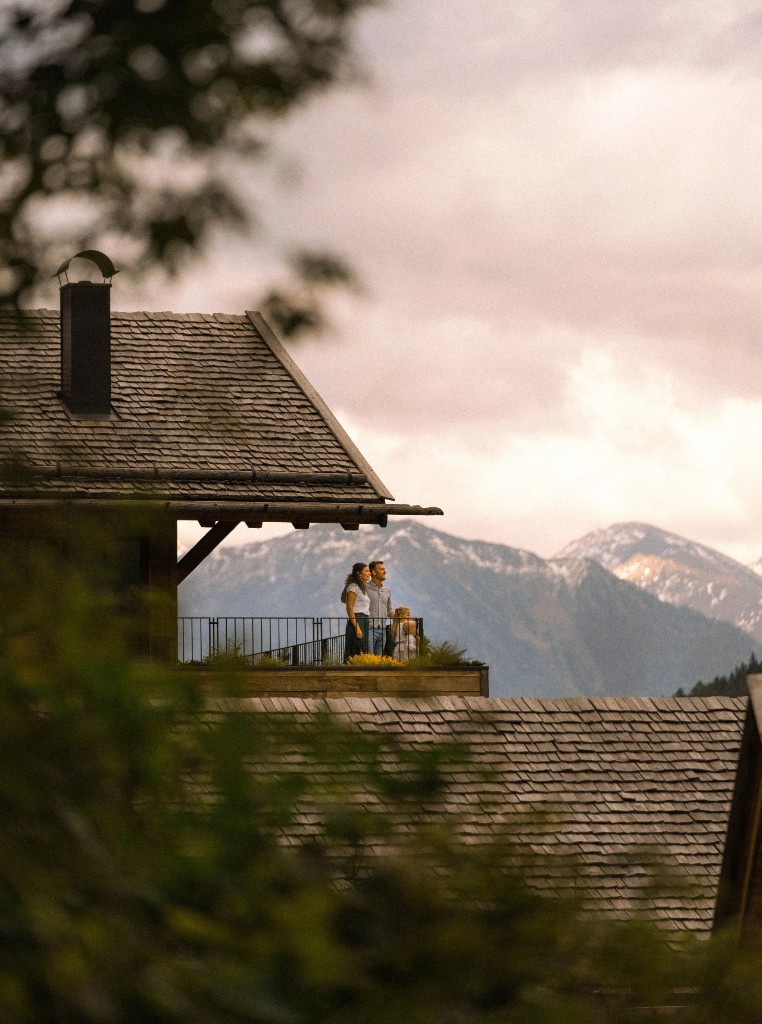 Family on a chalet balcony with mountain panorama