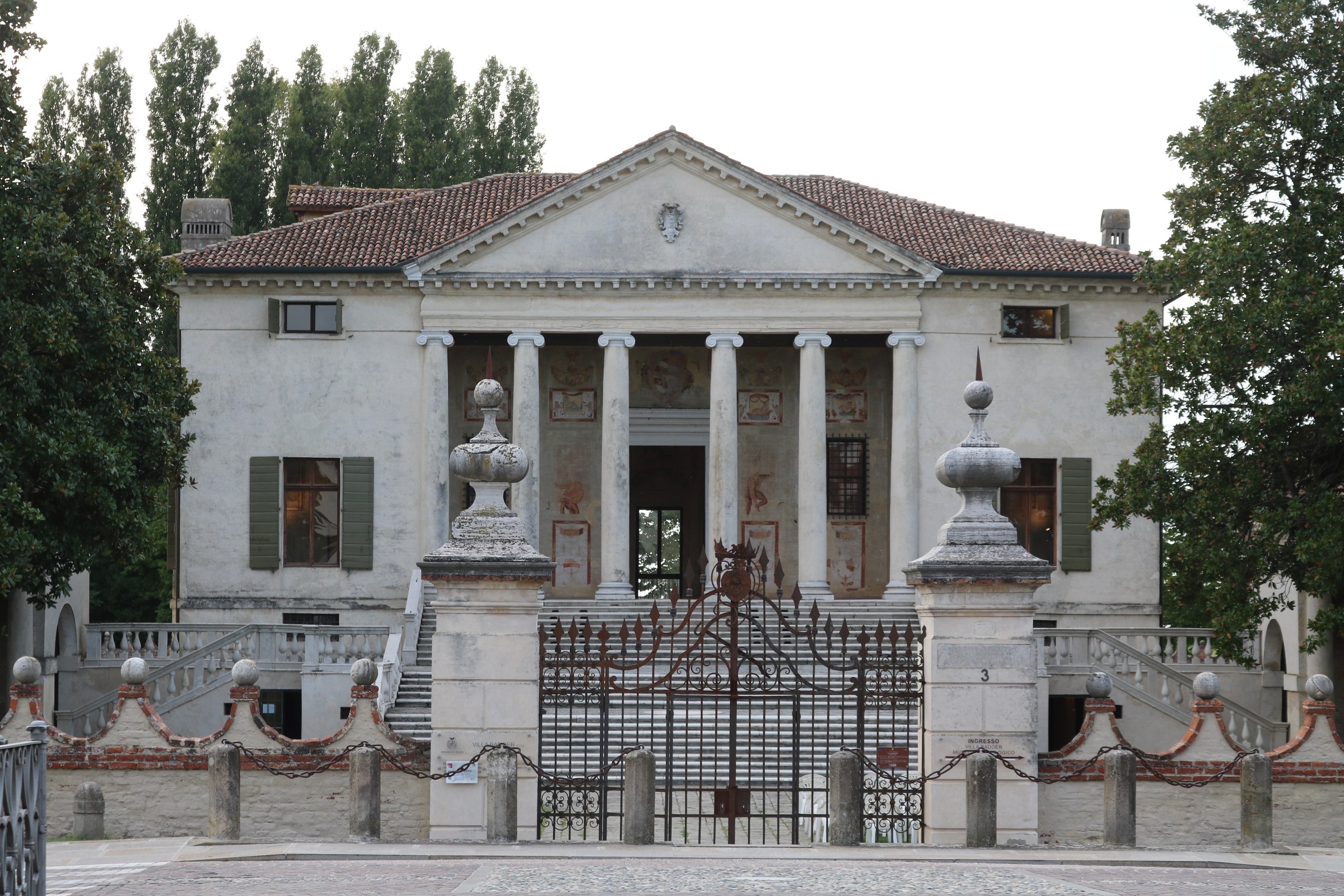 Villa Badoer, Fratta Polesine: raised Ionic portico seen through the entrance gate, with curved barchesse beyond