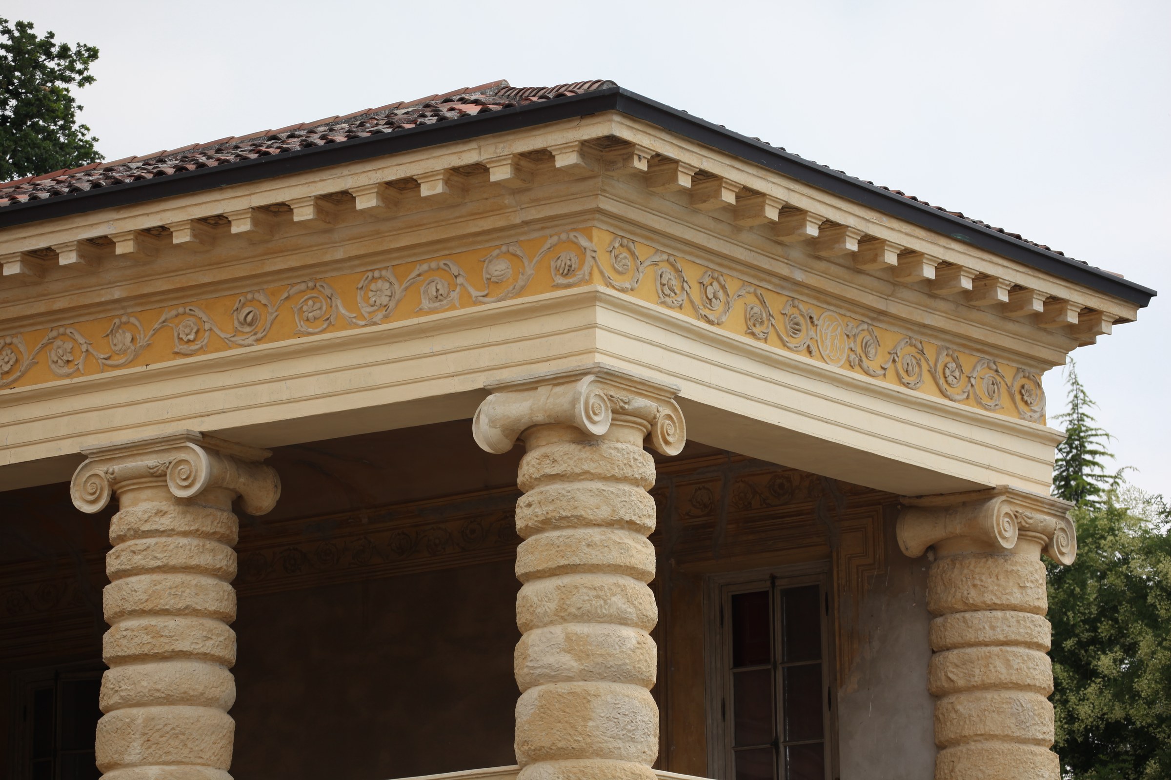 Villa Serego, Santa Sofia: rusticated stone column shafts with Ionic capitals and a painted frieze at the courtyard corner