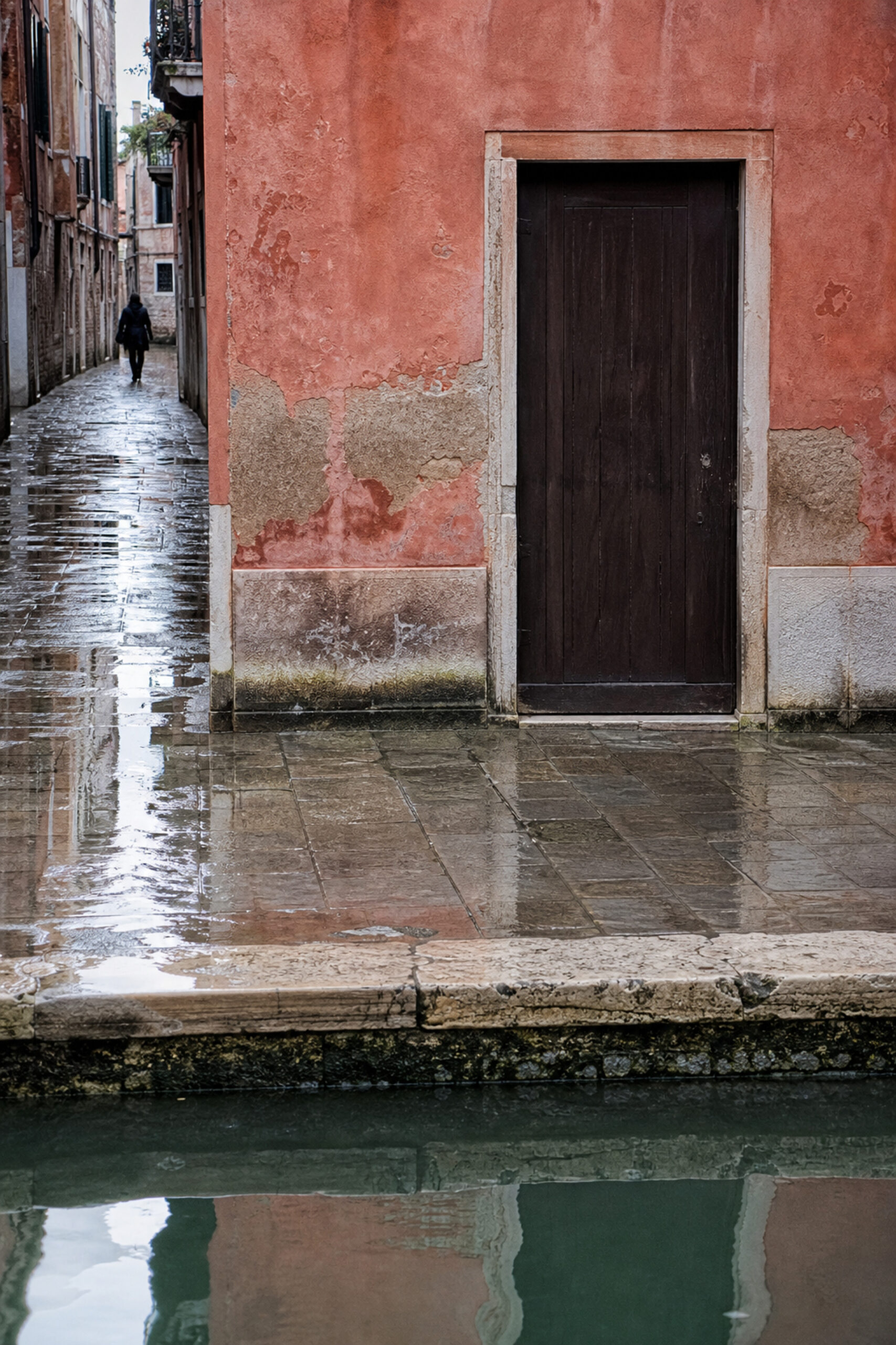 Narrow Venetian passage with wet stone and reflected canal light