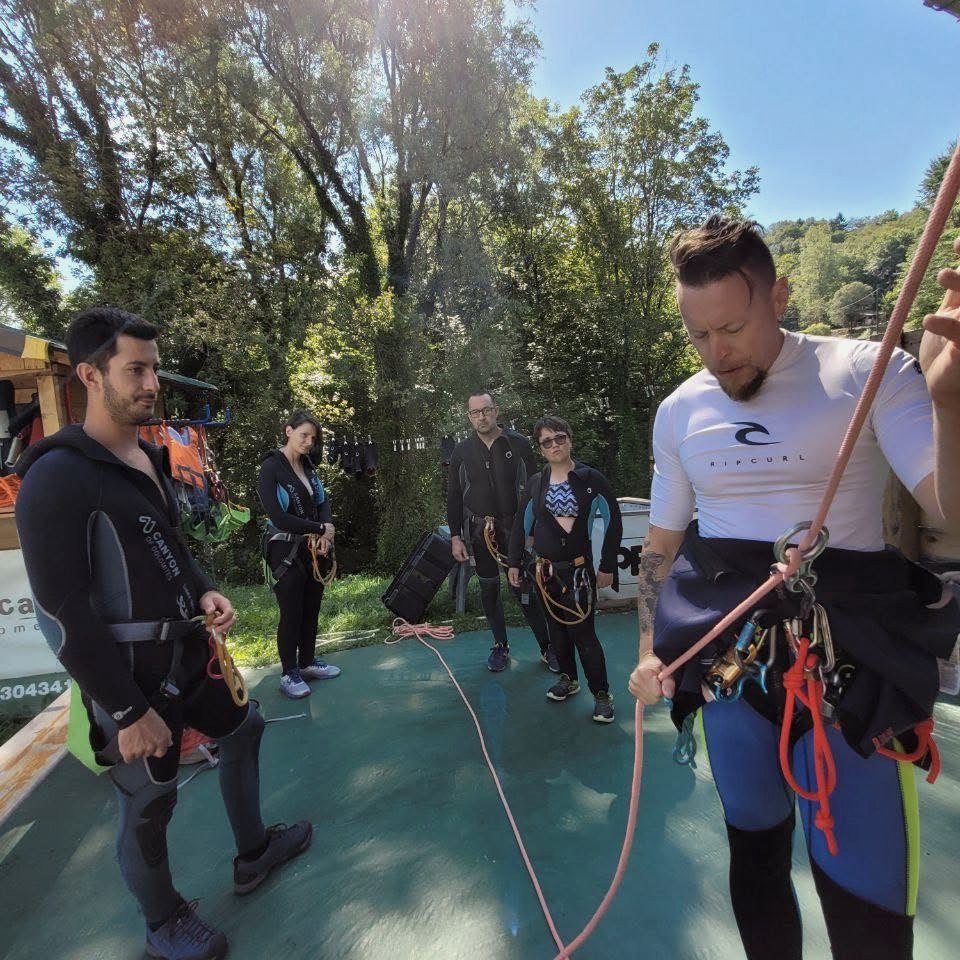 Outdoor guide checking a canyoning harness with a small group before entering the gorge, OHH! ITALY Journal