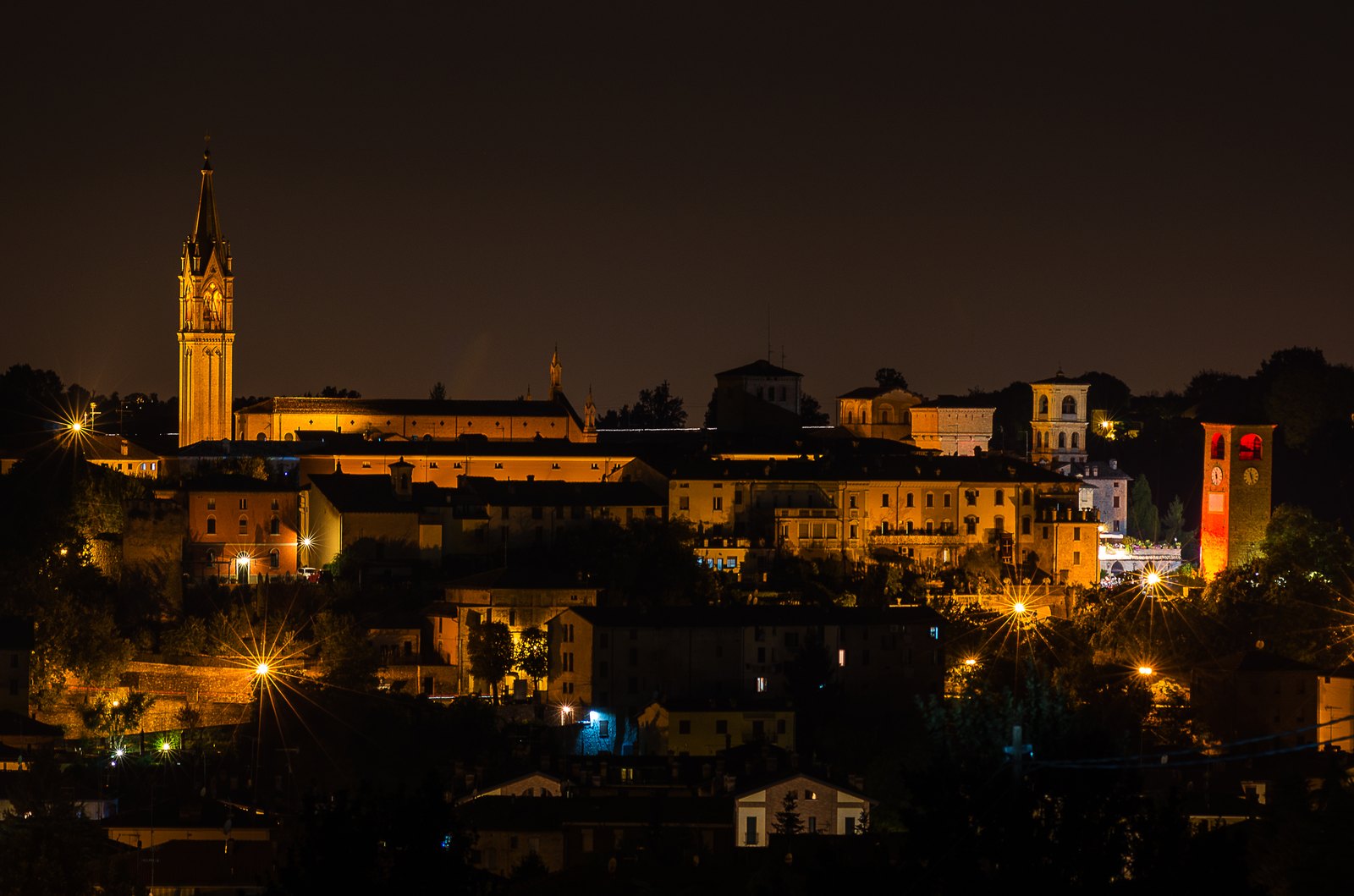Castelvetro di Modena on its hill after dark, towers and a civic profile.