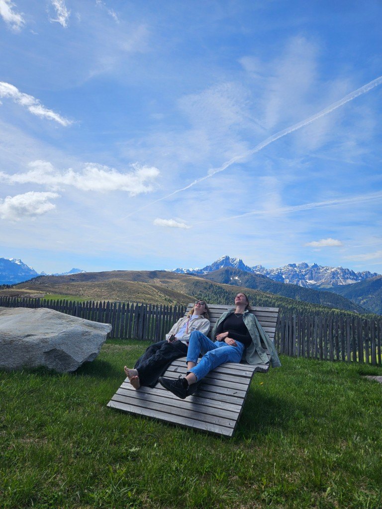 Two people on a wooden sunbed in the mountains during Summer Camp 2025